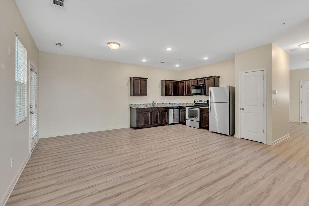 1938 Millstream Hollow Conyers, GA 30012 - Photo 5 of 16 a big room with wooden floor and kitchen view