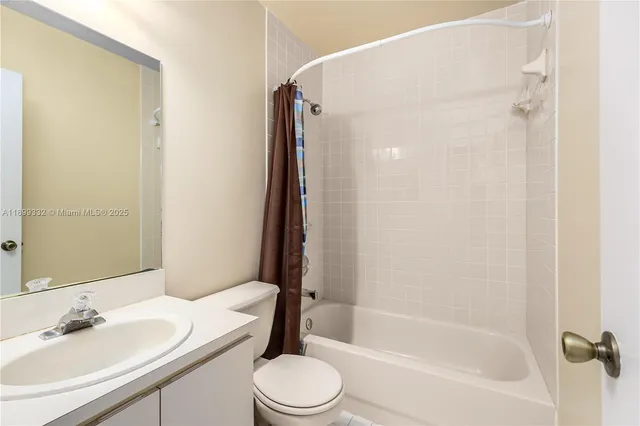 a bathroom with a bathtub shower sink vanity mirror and toilet