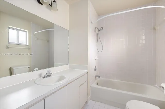 a bathroom with a granite countertop sink a toilet and shower