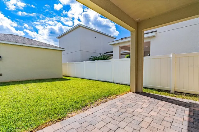 a front view of a house with a yard and potted plants