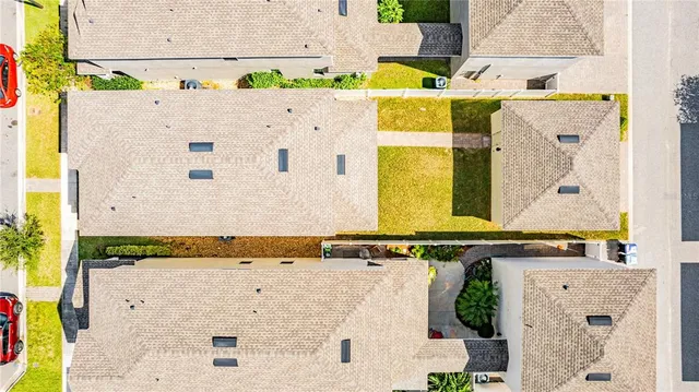 a view of a white house with a yard and potted plants