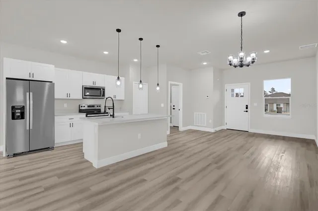 a view of a kitchen with a kitchen island wooden floor and a window
