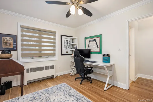 a view of a workspace with wooden floor and a window