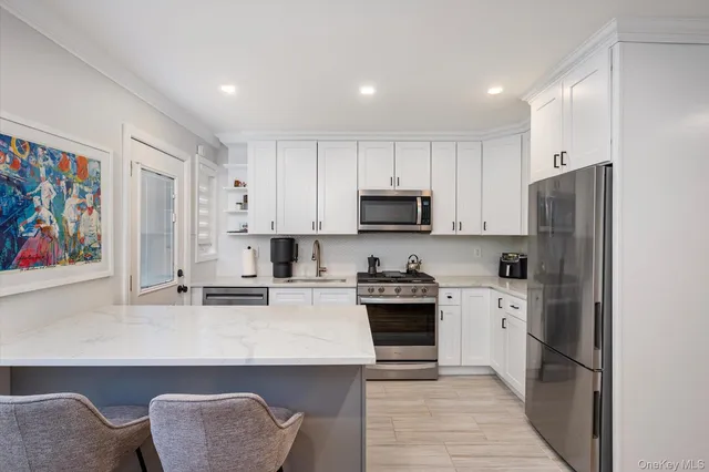 a kitchen with stainless steel appliances granite countertop a refrigerator stove microwave and sink