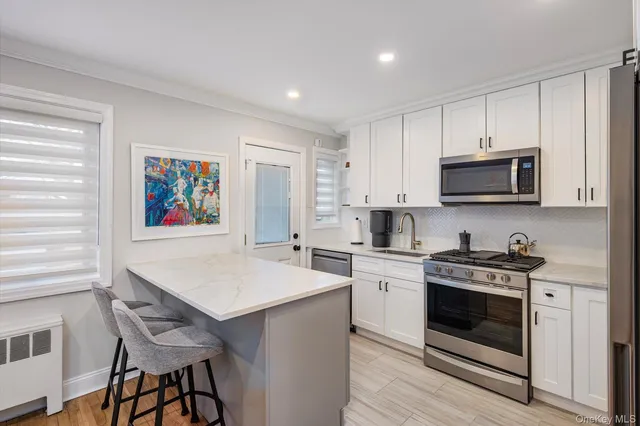 a kitchen with stainless steel appliances a stove sink microwave and cabinets