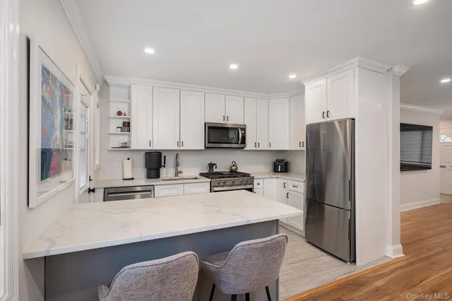 a kitchen with stainless steel appliances a refrigerator a stove top oven a sink and cabinets