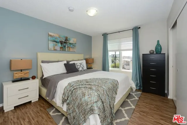 a bedroom with a bed and wooden floor