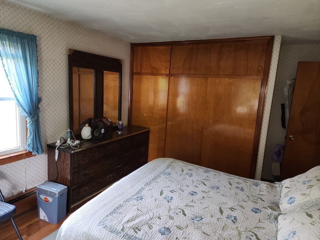 946 Bradley Road Springfield, MA 01109 - Photo 13 of 16 a bedroom with a bed and wooden floor