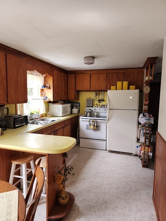 946 Bradley Road Springfield, MA 01109 - Photo 9 of 16 a kitchen with a table chairs a refrigerator and a window
