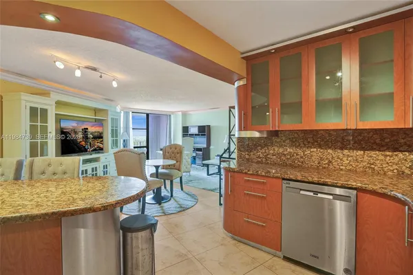 a living room with stainless steel appliances granite countertop furniture and a kitchen view