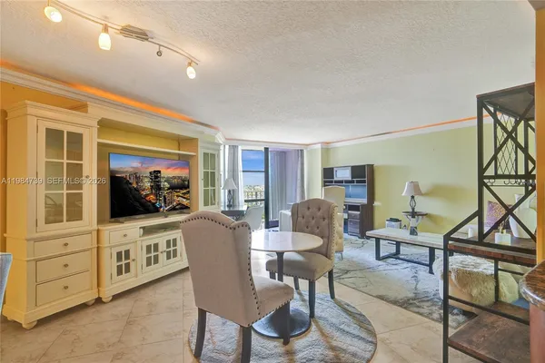 a living room with furniture a dining table and a flat screen tv