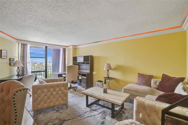 a living room with furniture kitchen view and a large window