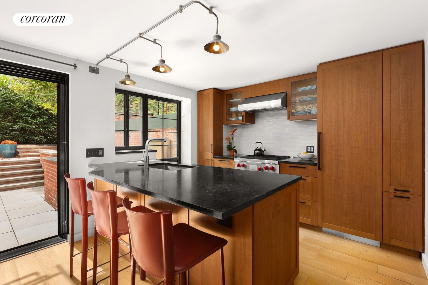 21 Bethune Street, Unit GARDEN Manhattan, NY 10014 - Photo 2 of 8 a kitchen with stainless steel appliances granite countertop a sink a stove and island
