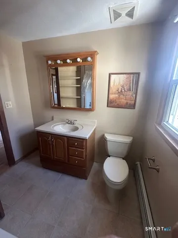 a bathroom with a toilet a sink and mirror