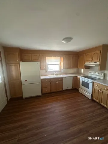 a view of a kitchen with a sink stove cabinets and empty room