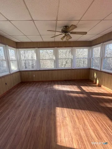 a view of empty room with wooden floor and fan