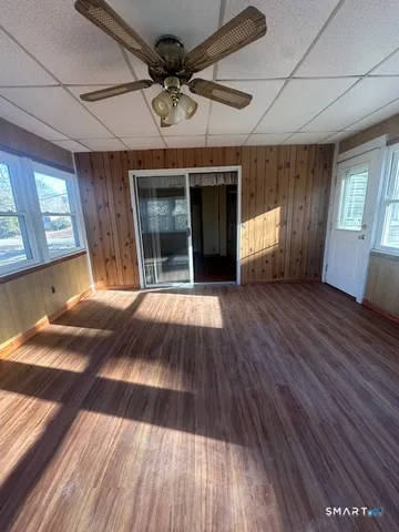 a view of an empty room with window and wooden floor