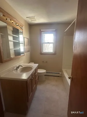 a bathroom with a double vanity sink toilet and a mirror