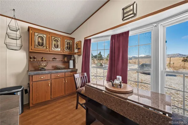 a kitchen with a refrigerator a stove a dining table and chairs with wooden floor