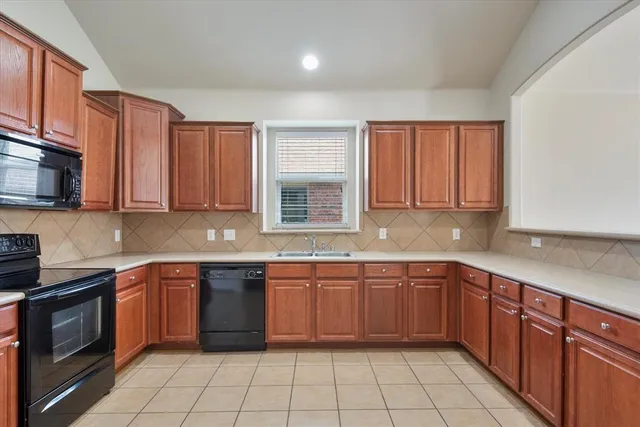 a kitchen with stainless steel appliances granite countertop white cabinets sink stove and microwave