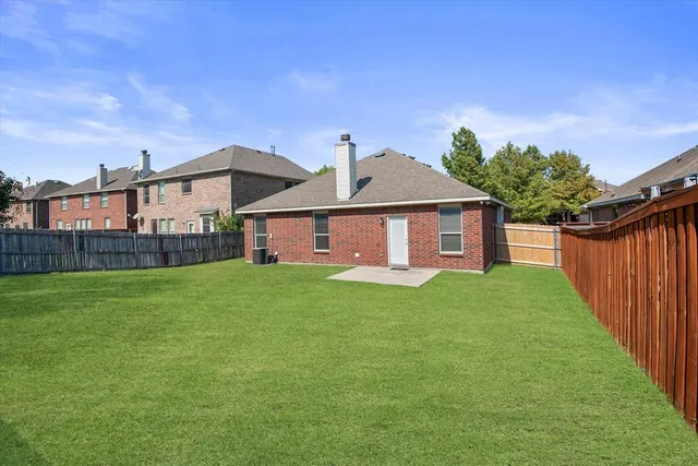 a view of a yard in front of a house with large trees