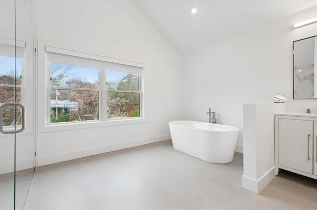 a bathroom with a white tub sitting next to a window