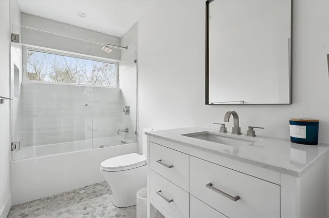 a bathroom with a granite countertop sink toilet and shower