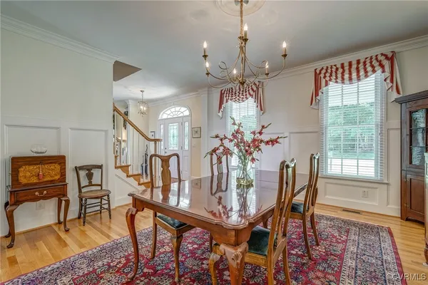 a view of a dining room with furniture and a chandelier