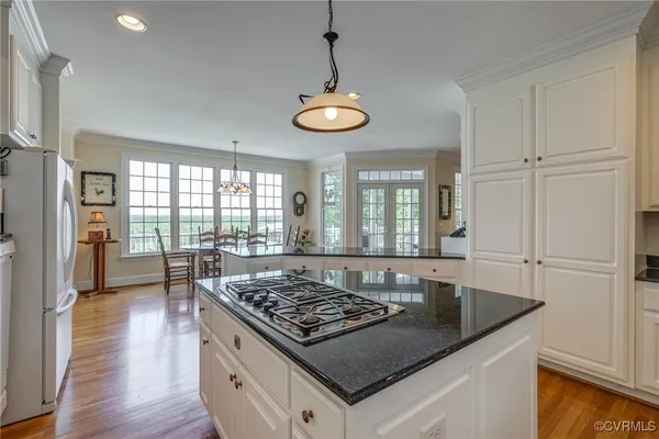 a kitchen with a table chairs and wooden floor