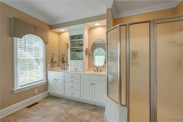 a spacious bathroom with a mirror a double vanity and a shower
