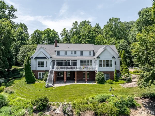 a view of a house with a big yard and large trees