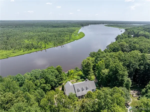 an aerial view of a house with a yard and lake view