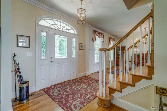 a view of a hallway with wooden floor and stairs