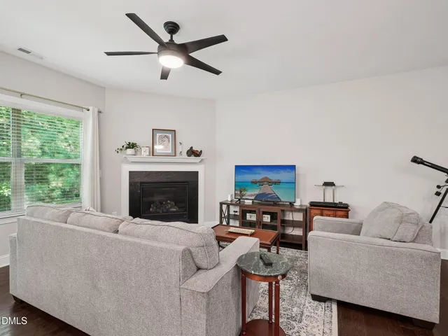 a living room with furniture a fireplace and a window