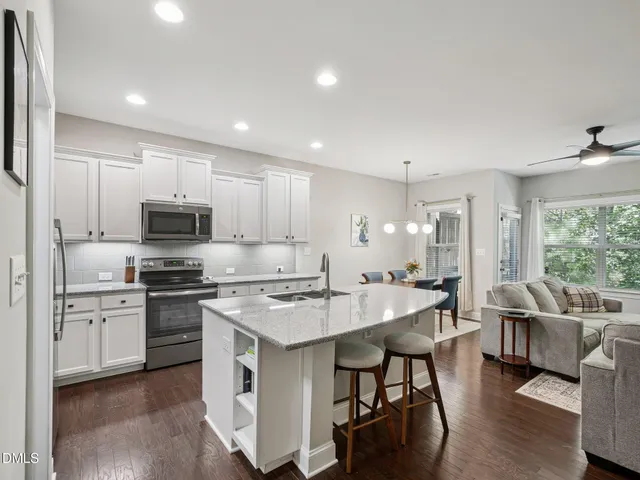 a kitchen with a dining table cabinets and appliances