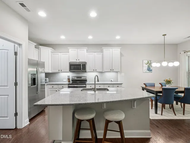 a large kitchen with cabinets table and chairs