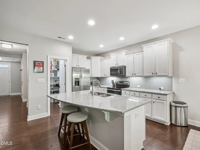 a kitchen with stainless steel appliances granite countertop a sink stove and microwave