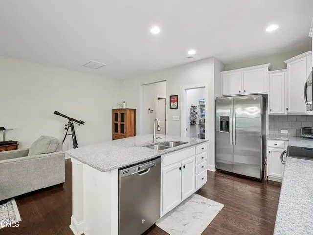 a kitchen with granite countertop a table chairs microwave and cabinets