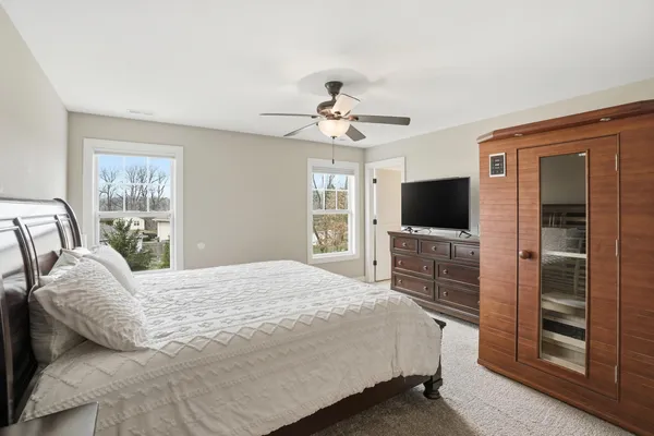 a bedroom with a bed flat screen tv and a window