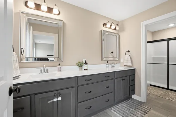 a bathroom with a double vanity sink and a mirror