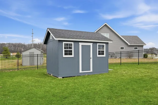 a backyard of a house with plants and wooden fence