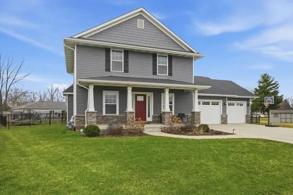 a front view of a house with a garden and yard