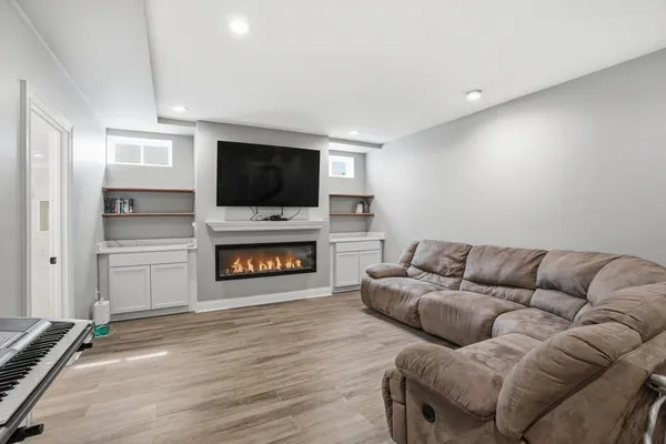 a living room with furniture a flat screen tv and a fireplace