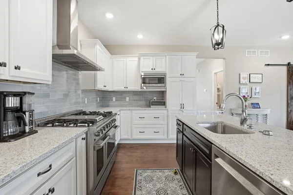 a kitchen with granite countertop a sink stove and cabinets