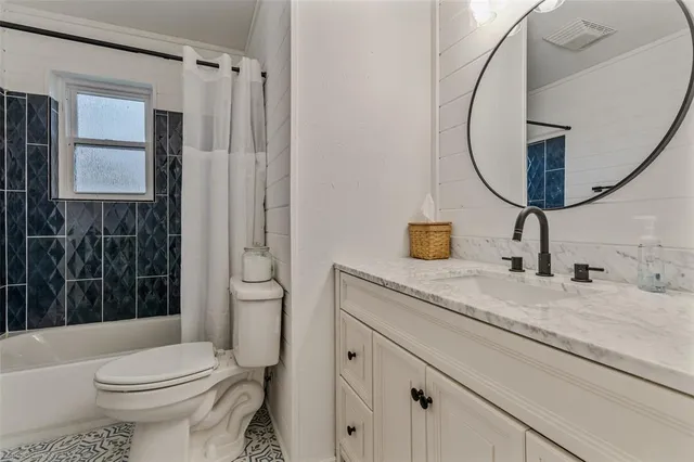 a bathroom with a granite countertop sink mirror vanity and toilet
