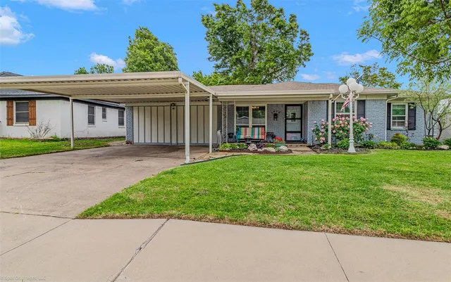 a view of a house with a yard and sitting area