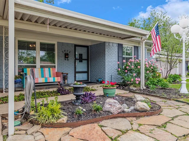 a front view of a house with plants and flowers