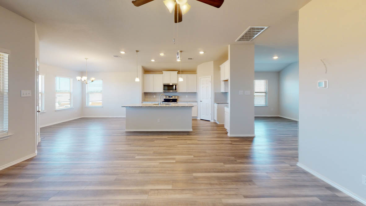 246 Water Wl Road Burnet, TX 78611 - Photo 16 of 16 a view of an empty room and kitchen with wooden floor