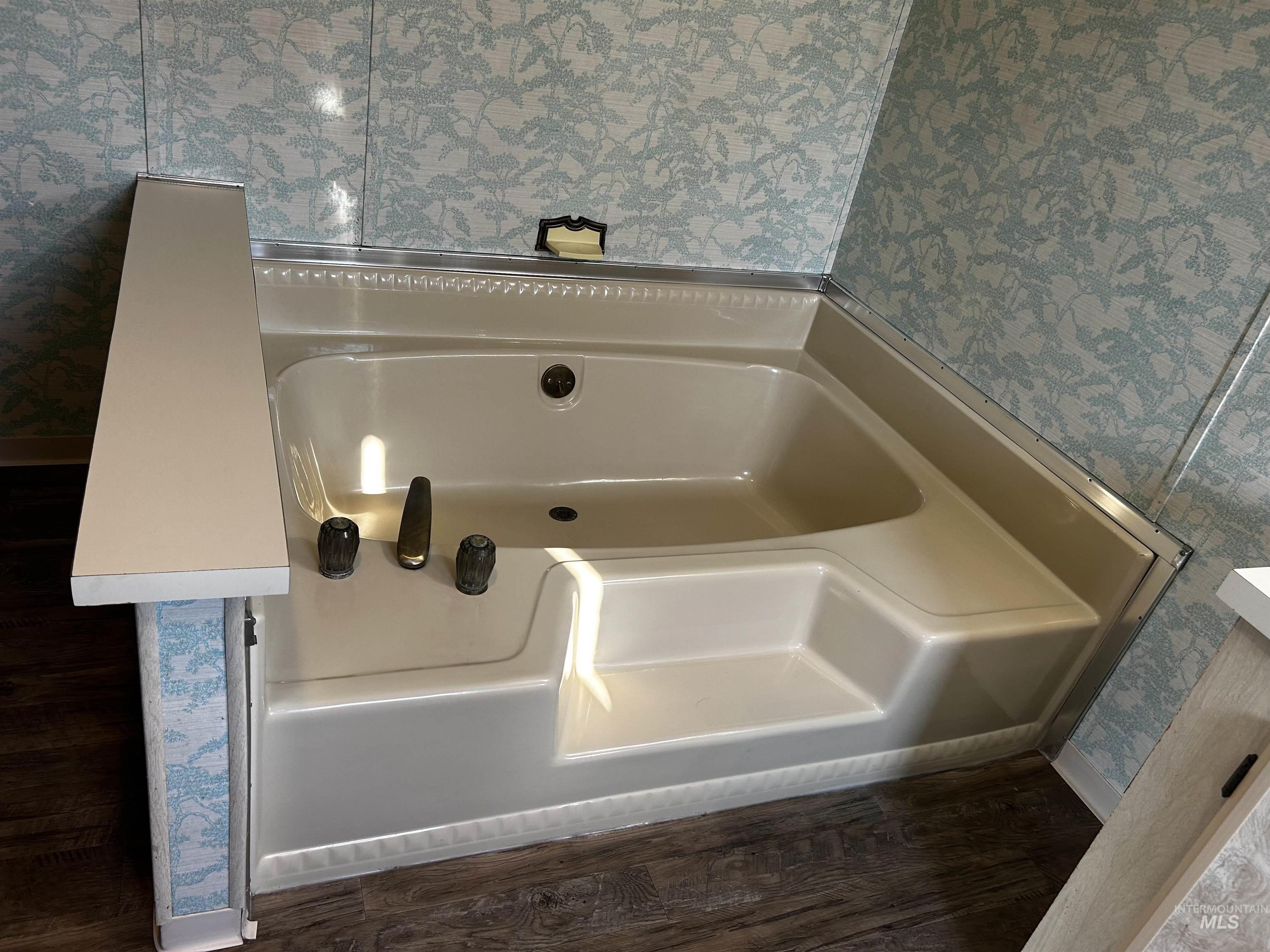 10165 West Claudia Road Boise, ID 83714 - Photo 24 of 30 Corner soaking tub with integrated steps, dark bronze fixtures, and patterned wall covering
