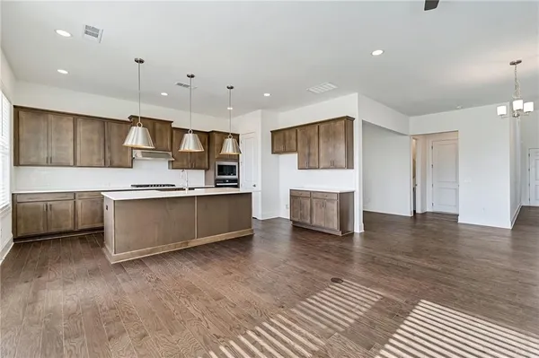 a large kitchen with kitchen island a sink stainless steel appliances and cabinets